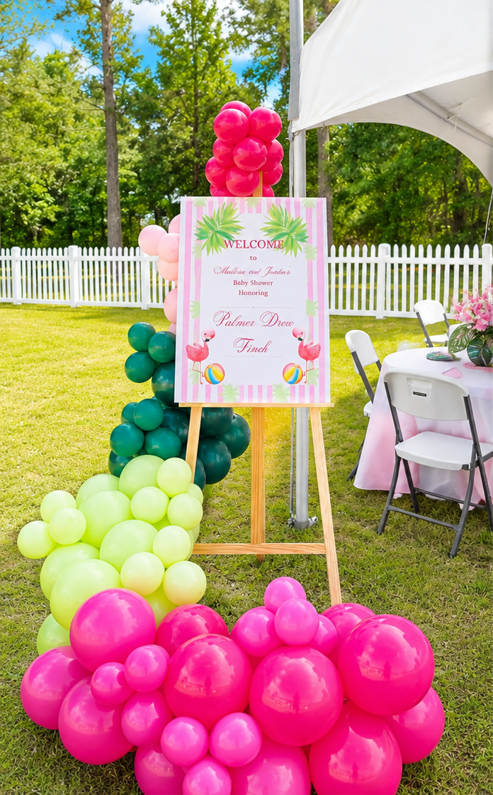 Flamingo welcome sign framed with a pink and green garland